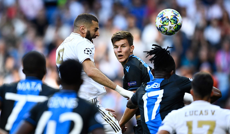 Real Madrid's French forward Karim Benzema (L) and Club Brugge's Ukrainian defender Eduard Sobol jump for the ball during the UEFA Champions league Group A football match between Real Madrid and Club Brugge at the Santiago Bernabeu stadium in Madrid on October 1, 2019. (Photo by OSCAR DEL POZO / AFP) (Photo credit should read OSCAR DEL POZO/AFP/Getty Images)