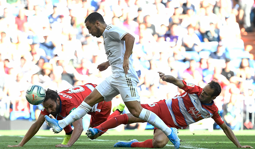 Real Madrid's Belgian forward Eden Hazard (C) shoots to score a goal during the Spanish league football match between Real Madrid CF and Granada FC at the Santiago Bernabeu stadium in Madrid on October 5, 2019. (Photo by PIERRE-PHILIPPE MARCOU / AFP) (Photo by PIERRE-PHILIPPE MARCOU/AFP via Getty Images)