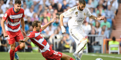 Granada's Spanish defender Victor Diaz (C) tackles Real Madrid's French forward Karim Benzema during the Spanish league football match between Real Madrid CF and Granada FC at the Santiago Bernabeu stadium in Madrid on October 5, 2019. (Photo by PIERRE-PHILIPPE MARCOU / AFP) (Photo by PIERRE-PHILIPPE MARCOU/AFP via Getty Images)