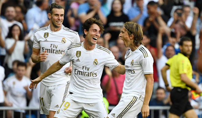 Real Madrid's Croatian midfielder Luka Modric (R) celebrates scoring his team's third goal beside Real Madrid's Spanish defender Alvaro Odriozola and Real Madrid's Welsh forward Gareth Bale (L) during the Spanish league football match between Real Madrid CF and Granada FC at the Santiago Bernabeu stadium in Madrid on October 5, 2019. (Photo by PIERRE-PHILIPPE MARCOU / AFP) (Photo by PIERRE-PHILIPPE MARCOU/AFP via Getty Images)