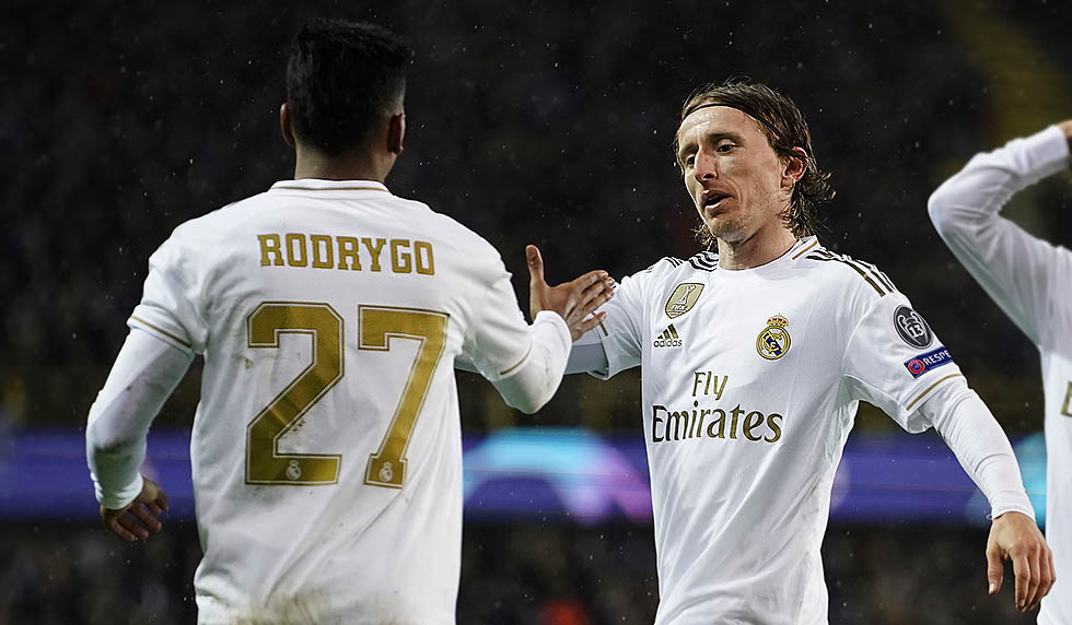 Real Madrid's Brazilian forward Rodrygo (L) celebrates with Real Madrid's Croatian midfielder Luka Modric (C) and Real Madrid's Spanish defender Alvaro Odriozola after scoring the opener during the UEFA Champions League Group A football match between Club Brugge and Real Madrid CF at the Jan Breydel Stadium in Bruges on December 11, 2019. (Photo by KENZO TRIBOUILLARD / AFP) (Photo by KENZO TRIBOUILLARD/AFP via Getty Images)