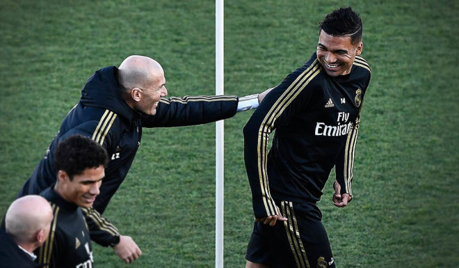 Real Madrid's French coach Zinedine Zidane jokes with Real Madrid's Brazilian midfielder Casemiro (R) during a public training session at the Ciudad Real Madrid training ground in Valdebebas, Madrid, on December 30, 2019. (Photo by OSCAR DEL POZO / AFP) (Photo by OSCAR DEL POZO/AFP via Getty Images)